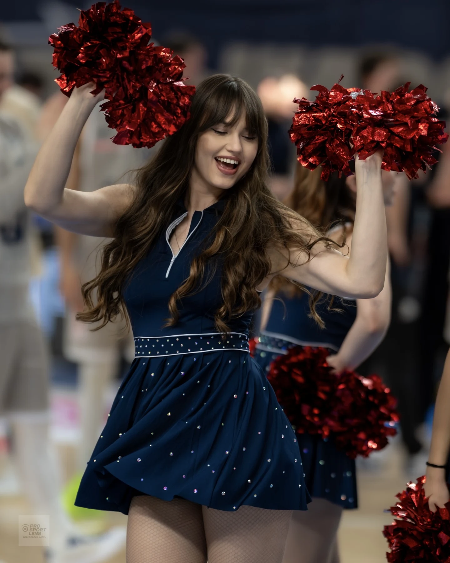 Warsaw Cheerleaders z czerwonymi pomponami podczas występu